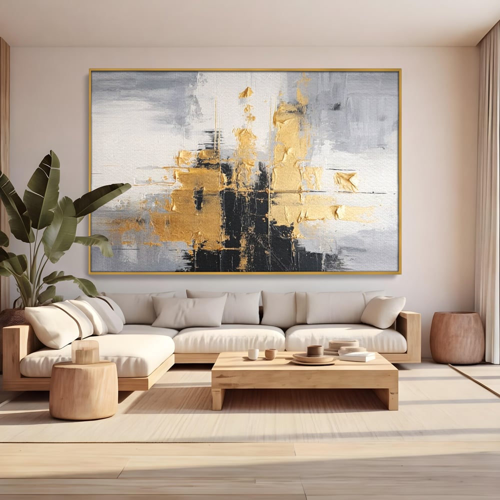 Tablou canvas cu pictura abstracta cu auriu si negru, in rama de aluminiu auriu, pe perete intr-un living
